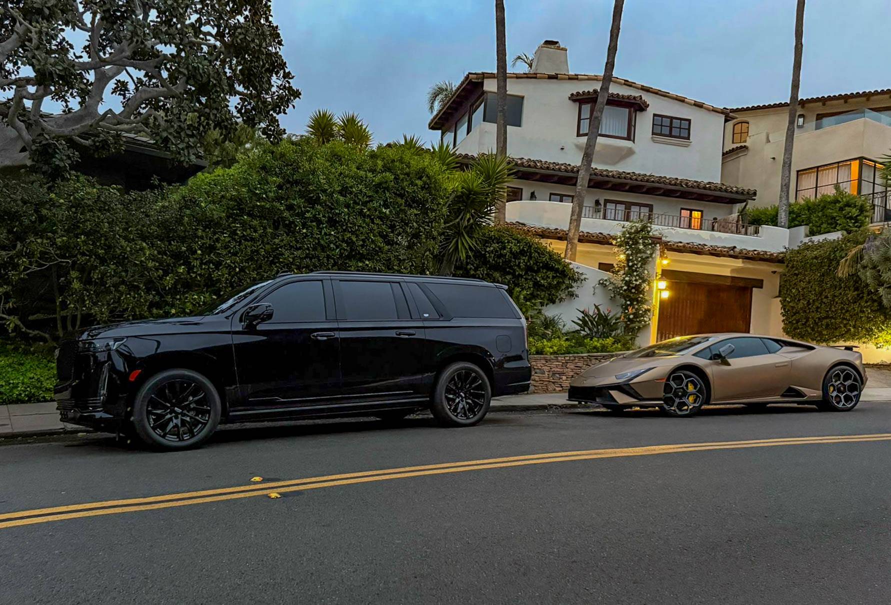 Black car service San Diego Escalade SUV parked near luxury home with palm trees