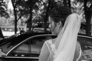 Bride entering luxury black car for wedding transportation by Black On Black Limo in San Diego