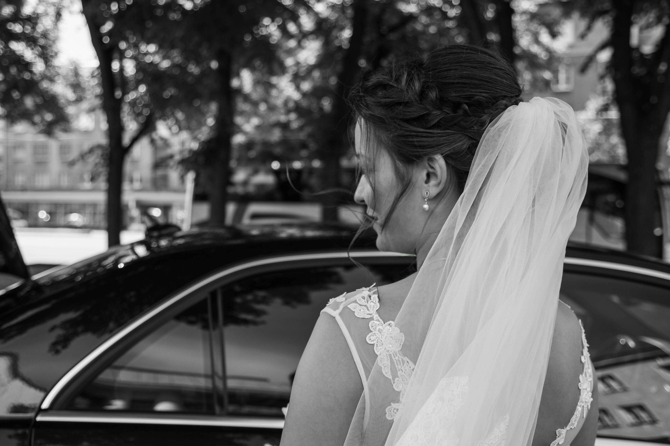 Bride entering luxury black car for wedding transportation by Black On Black Limo in San Diego